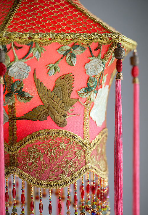 Detail of 1920s antique floor lamp with scrolls has been hand painted and holds a hand-dyed exotic Chinoiserie Red Lantern with Cranes silk lampshade. 